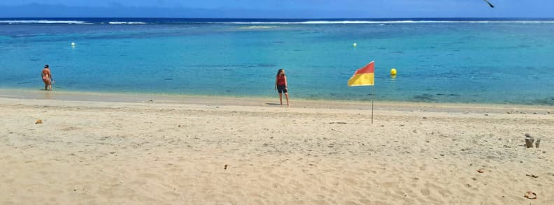 Mirela Letailleur, The Travel Bunny, on the beach in the L'Hermitage lagoon on Reunion Island, with calm water, a protective reef and a safe swimming area