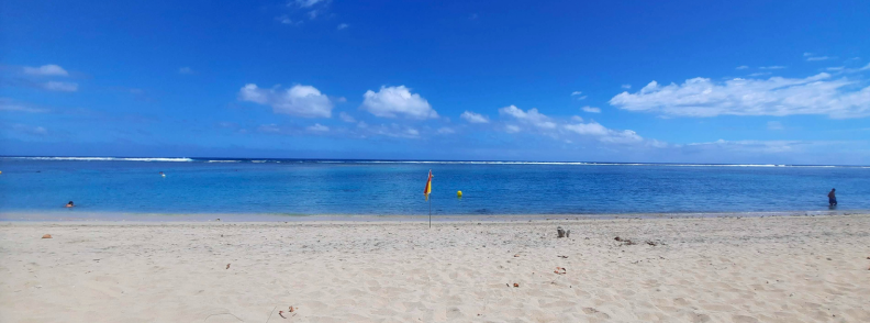 Calm lagoon and white sand at Plage de l’Hermitage on the west coast of Réunion Island with a flagged swimming zone