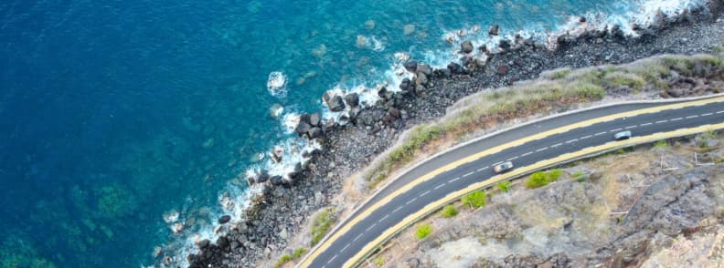 Aerial view of the RN1A coastal road following the shoreline on Réunion Island between ocean and volcanic rock