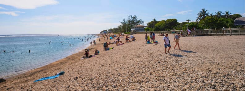 People relaxing and swimming at Saint-Pierre beach on the south coast of Réunion Island near the waterfront