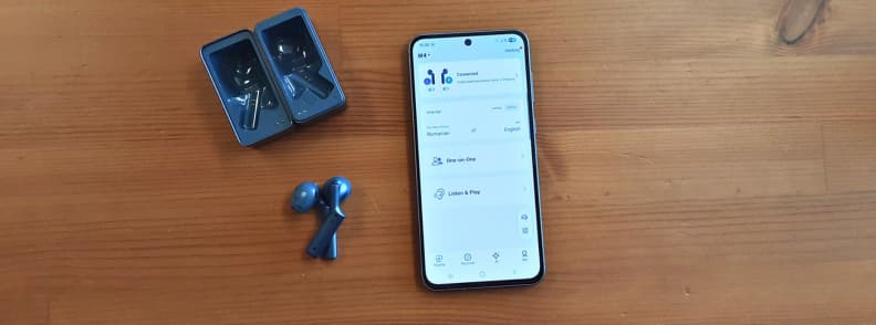 Timekettle W4 AI Interpreter Earbuds with charging case and smartphone showing translation app during battery life testing.