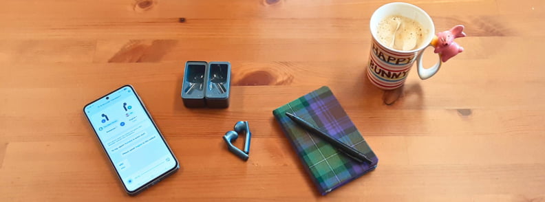 Timekettle W4 AI Interpreter Earbuds with smartphone translation app notebook and coffee setup for real world testing.