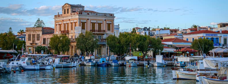 Aegina Island Greece harbor with fishing boats and neoclassical buildings during an Aegina island day trip from Athens
