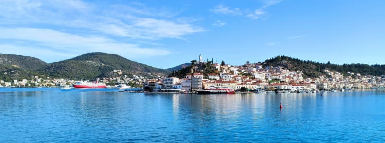 Poros island coastline with calm sea during an Athens to Hydra Poros Aegina cruise