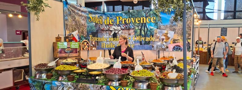 foire de brignoles provence gastronomy hall local food olive tasting Provençal food stand at the Foire de Brignoles gastronomy hall displaying olives, tapenades, and local specialties for tasting.