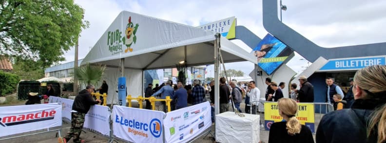 foire de brignoles west entrance ticket office access points brignoles parc Visitors entering the Foire de Brignoles through the West entrance near the billeterie, with queues forming at the ticket office and signage for access points and parking.