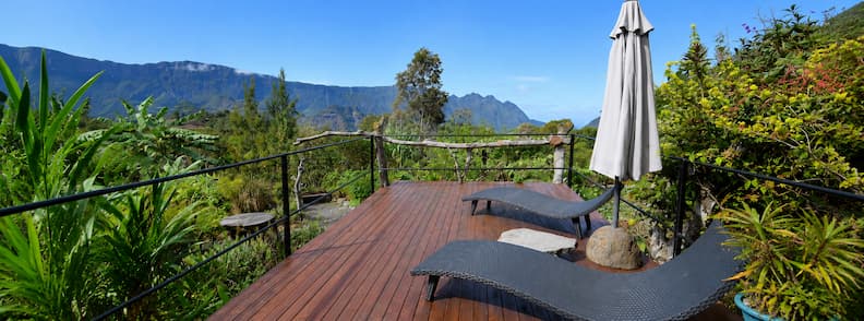 Wooden deck with two lounge chairs and mountain views at Gîte Le Tapacala in Cirque de Mafate, La Réunion.