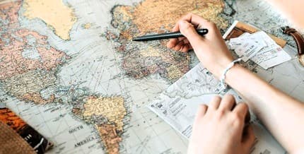 custom europe itinerary planning mediterranean travel consulting Mirela The Travel Bunny planning a Europe itinerary on a map with travel tickets, notes, and Mediterranean travel routes.