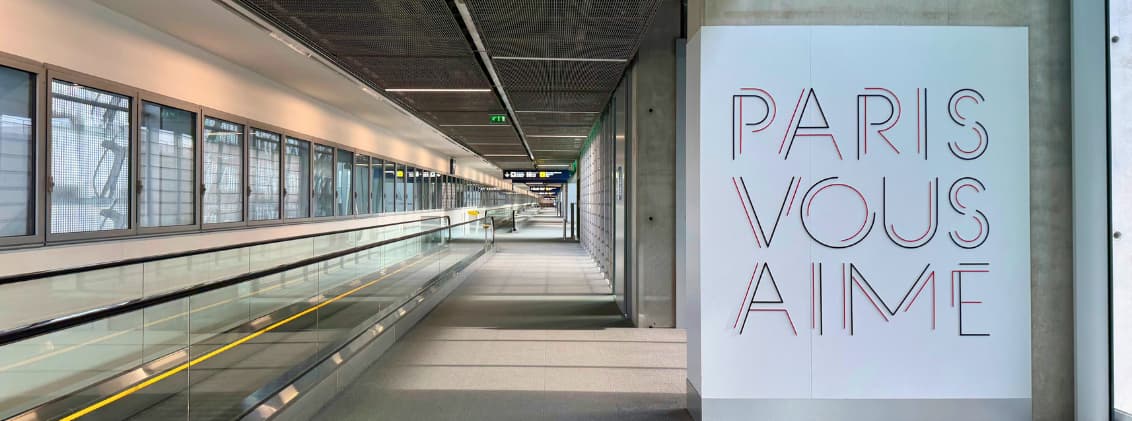 how to get to la reunion flights from paris cdg reunion island Departure corridor at Paris Charles de Gaulle Airport before flights to La Réunion, with airport walkways and a Paris Vous Aime sign inside the terminal.