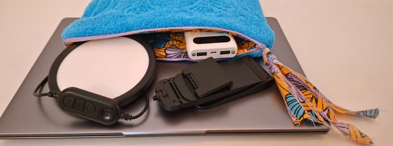 LitONES VersaGlow V01 packed beside a laptop, power bank, and microfiber towel during a travel creator portability and packing test.