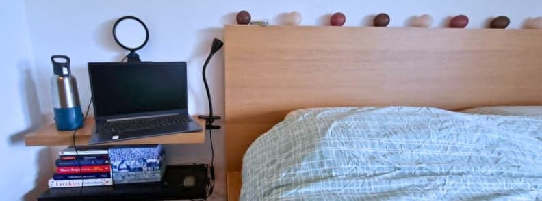 LitONES VersaGlow V01 review showing a compact laptop workspace beside a bed during digital nomad and hotel-room remote work testing.
