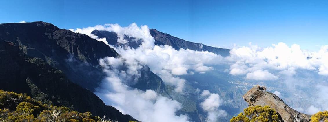 piton des neiges hike highest peak la reunion View of Piton des Neiges from Grand Bénare in La Réunion, with mountain ridges, clouds filling the cirques, and high-altitude volcanic landscapes.