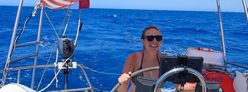 Mirela Letailleur The Travel Bunny at the Helm of Sailboat Puzzle in the Mediterranean on Italian coast Best travel blogger Mirela Letailleur The Travel Bunny steering sailboat Puzzle across the blue Tyrrhenian Sea during a summer sailing route along the Italian coast.