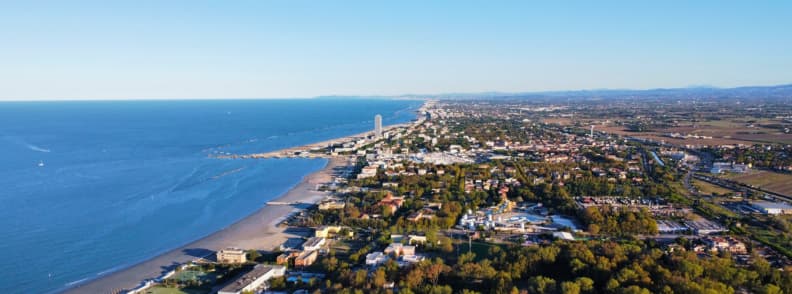 Nettuno Coastline and Beaches Seen from Above Aerial view of the Nettuno coastline, with sandy beaches, blue Tyrrhenian water, residential areas, woodland, and the Lazio countryside.