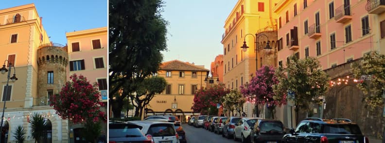 Nettuno Old Town Street and Medieval Tower Homes Colorful buildings and a medieval tower along a residential street in Nettuno old town, with flowering trees, balconies, and parked cars.