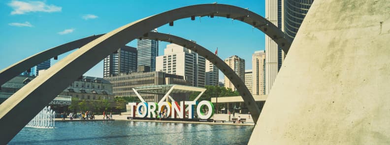 Best Time to Visit Toronto Nathan Phillips Square Toronto sign at Nathan Phillips Square under blue skies during a sunny day in downtown Toronto.