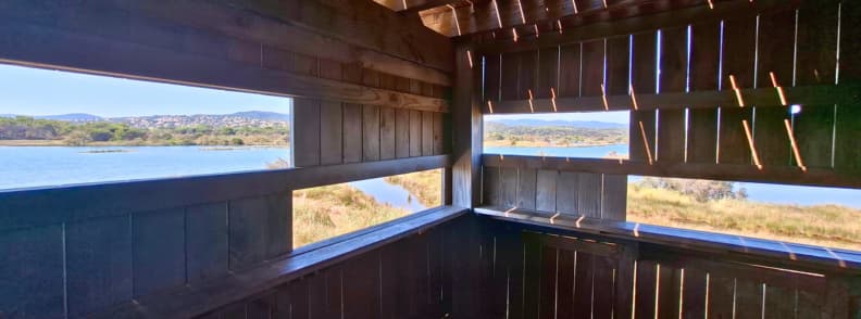 View across the Étangs de Villepey lagoons from inside a wooden birdwatching observatory in Saint-Aygulf, Fréjus.