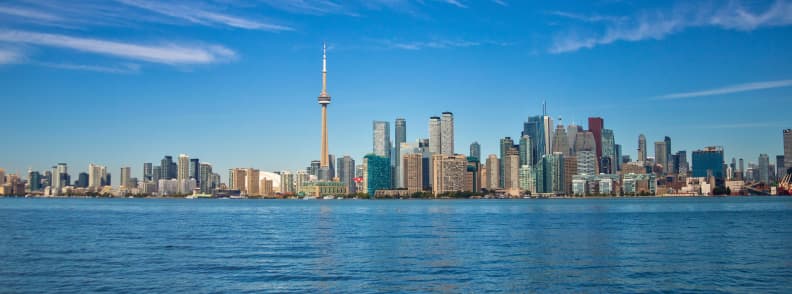 CN Tower Toronto Skyline Two Day Couples Itinerary CN Tower rising above the downtown Toronto skyline across Lake Ontario on a clear morning.