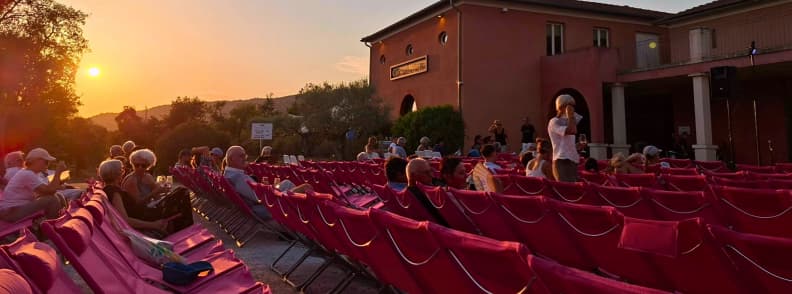 Guests arriving and settling into pink chiliennes at Château du Rouët during sunset before a Les Musicales dans les Vignes concert in Provence.