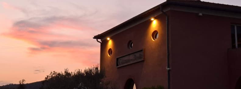 Château du Rouët estate building illuminated at sunset under a pink evening sky near Le Muy in the Var, Provence.