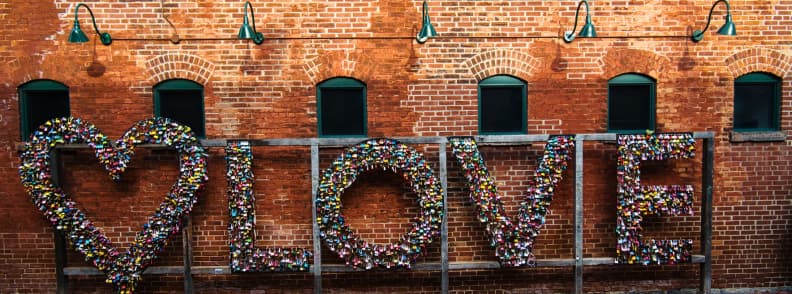 Distillery District Love Locks Toronto Couples Itinerary Heart-shaped Love Locks installation against a red brick wall in Toronto’s Distillery Historic District.