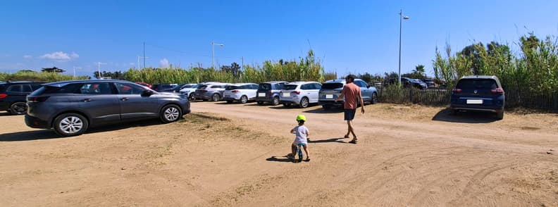 Man and toddler walking through the Étangs de Villepey parking area at Esclamandes in Saint-Aygulf, Fréjus.