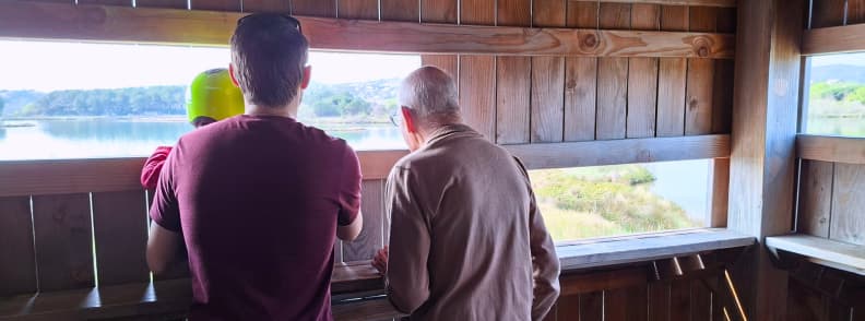 My husband, toddler, and father-in-law looking across the Étangs de Villepey wetlands from a wooden birdwatching observatory in Saint-Aygulf.