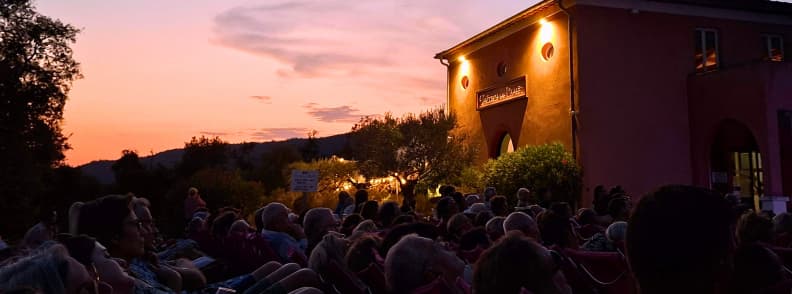 Guests seated outside Château du Rouët during a pink sunset at a Les Musicales dans les Vignes concert in Provence.