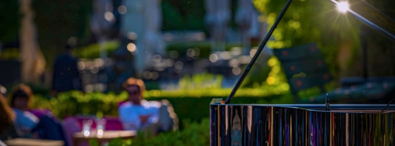 Grand piano beside seated guests at an outdoor Les Musicales dans les Vignes concert in Provence during the early evening.