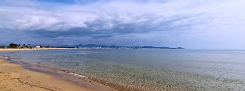 Sandy Saint-Aygulf beach near Étangs de Villepey overlooking calm Mediterranean water and the coastline toward Fréjus.