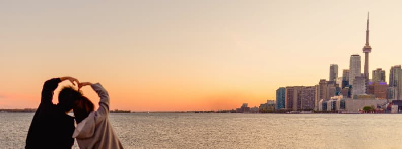 Toronto Itinerary for Couples. Couple overlooking the Toronto skyline and CN Tower during a two-day city break