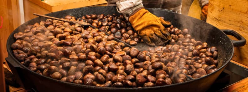 Chestnut Fair Provence Var Autumn Food Festivals Roasted chestnuts steam in a large black pan as a vendor stirs them at an autumn chestnut fair in Provence.