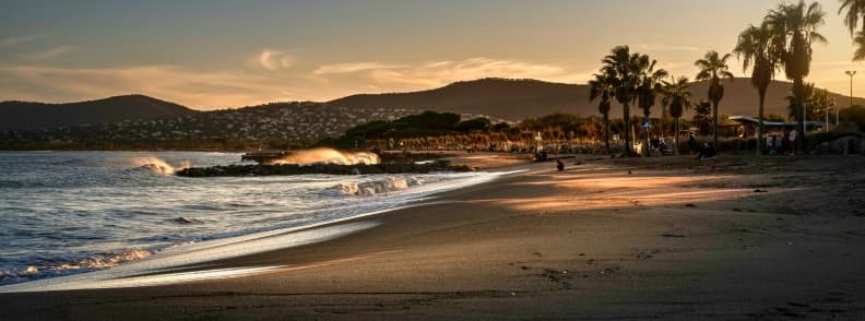Late Autumn Frejus Saint Raphael and Esterel Coast Late autumn beach near Fréjus and Saint-Raphaël, with waves, palm trees, the Estérel hills, and warm sunset light on the western Riviera.