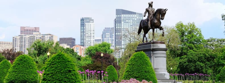 Boston Public Garden George Washington Statue Free things to do in Boston guide. George Washington equestrian statue surrounded by spring flowers and greenery in Boston Public Garden.