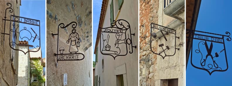 Circuit des Enseignes Mons Var Old Trade Signs Five wrought-iron trade signs on the Circuit des Enseignes in Mons Var, including the barber, milkmaid, notary, and two different Tailleur signs along the old village streets.