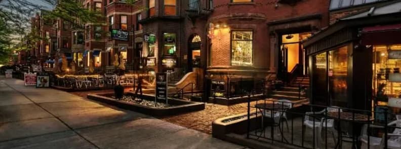 Newbury Street Boston Back Bay Shopping District Evening view of brownstone storefronts, sidewalk cafés, and boutiques along Newbury Street in Boston’s Back Bay.
