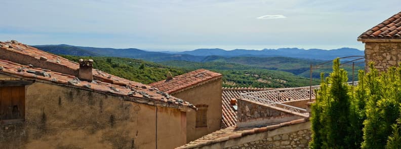 Where Is Mons Var Village in Pays de Fayence Tiled rooftops of Mons Var overlooking the wooded Pays de Fayence hills and distant mountain ridges in Provence.